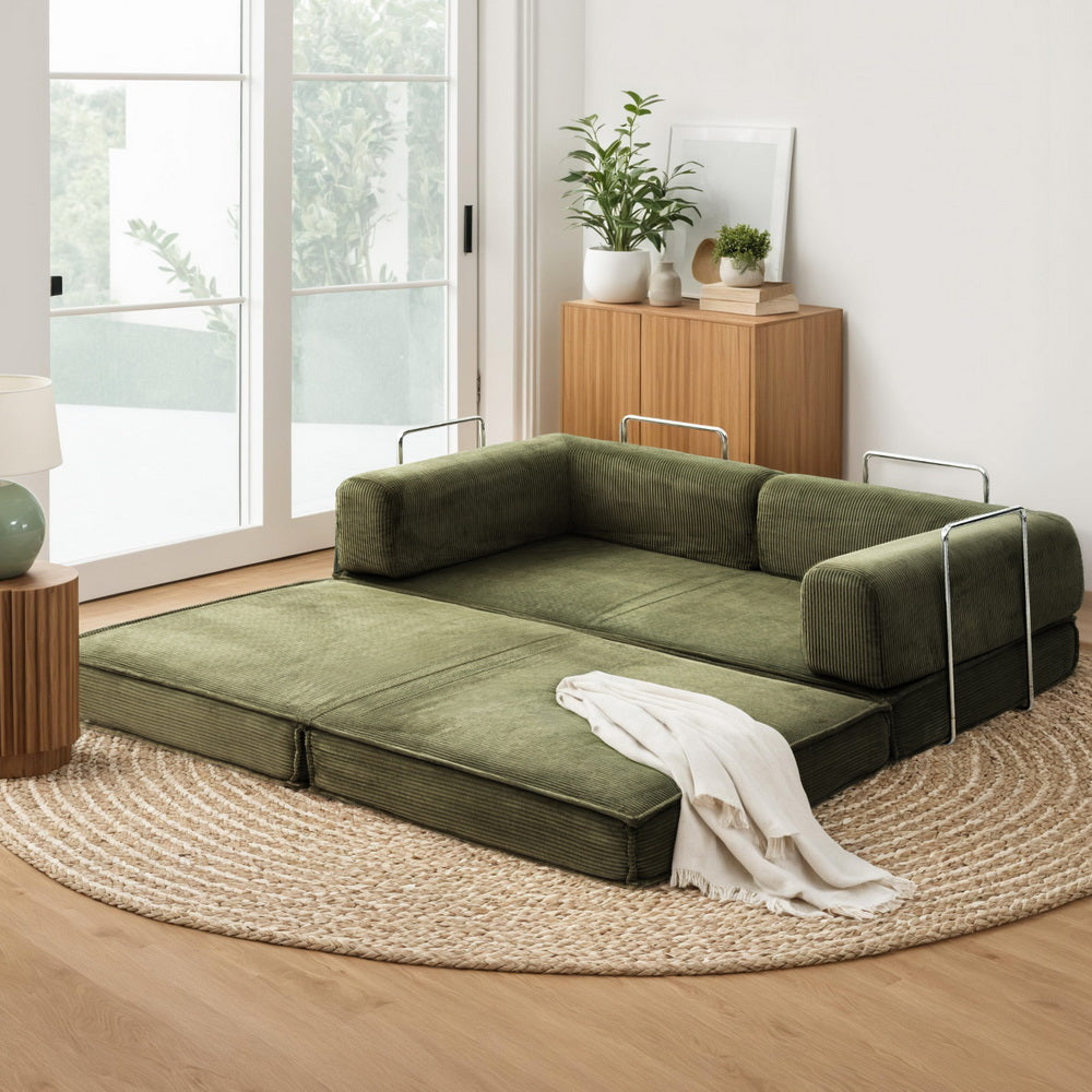 Convertible Folding Sofa Bed Green in a living room setting with metal frame and soft cushions on a round woven rug