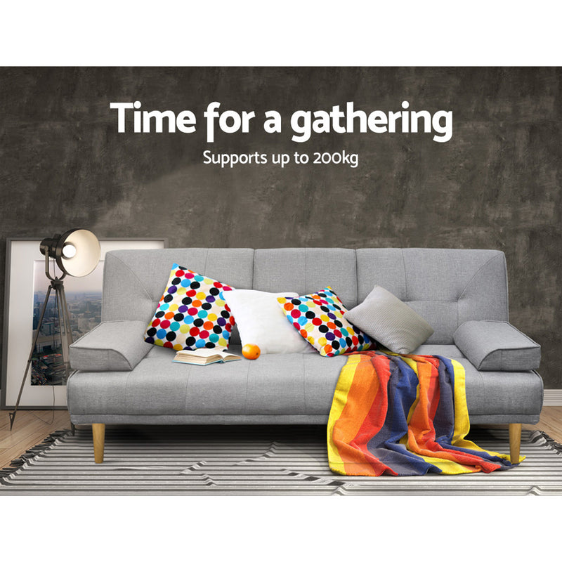 3 Seater Fabric Sofa Bed (Grey) with colorful cushions, wooden legs, and a striped throw on a patterned rug in a modern room