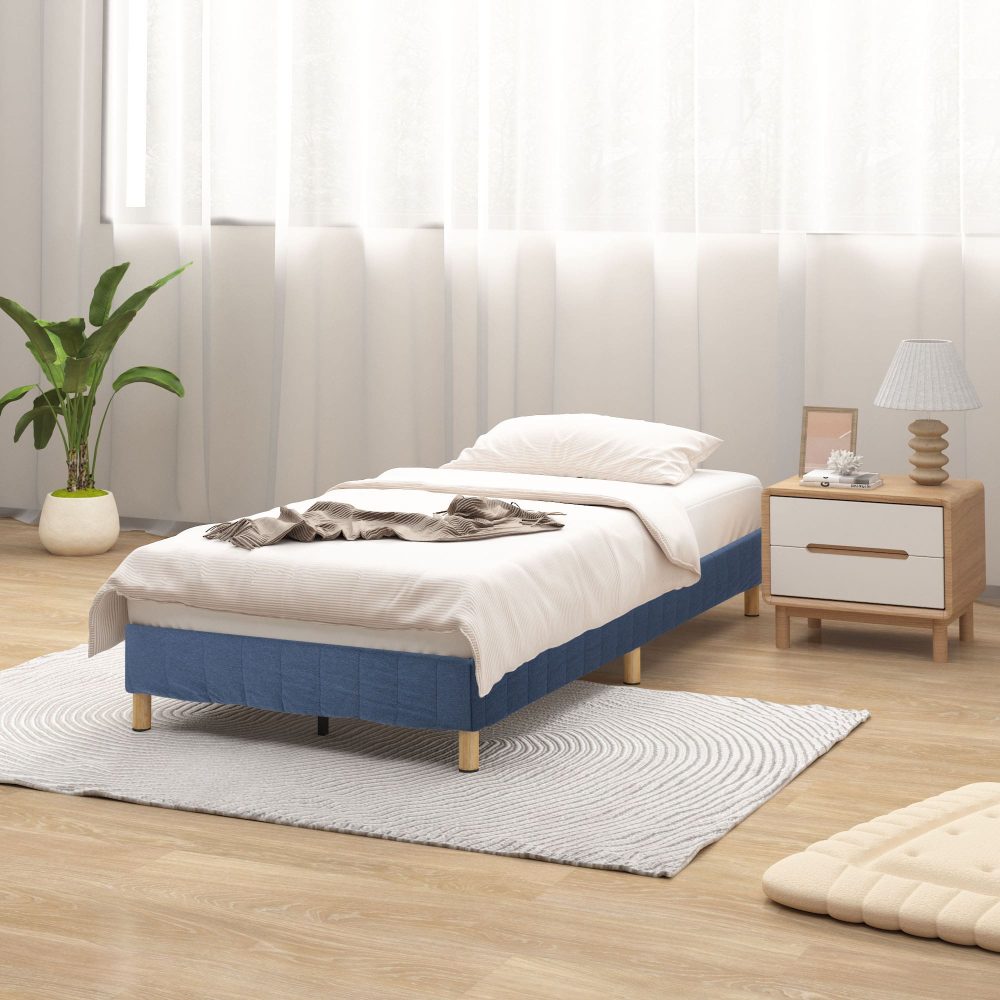 Single Metal Bed Frame Mattress Foundation - Blue with wooden legs in bright bedroom setting with side table and plant