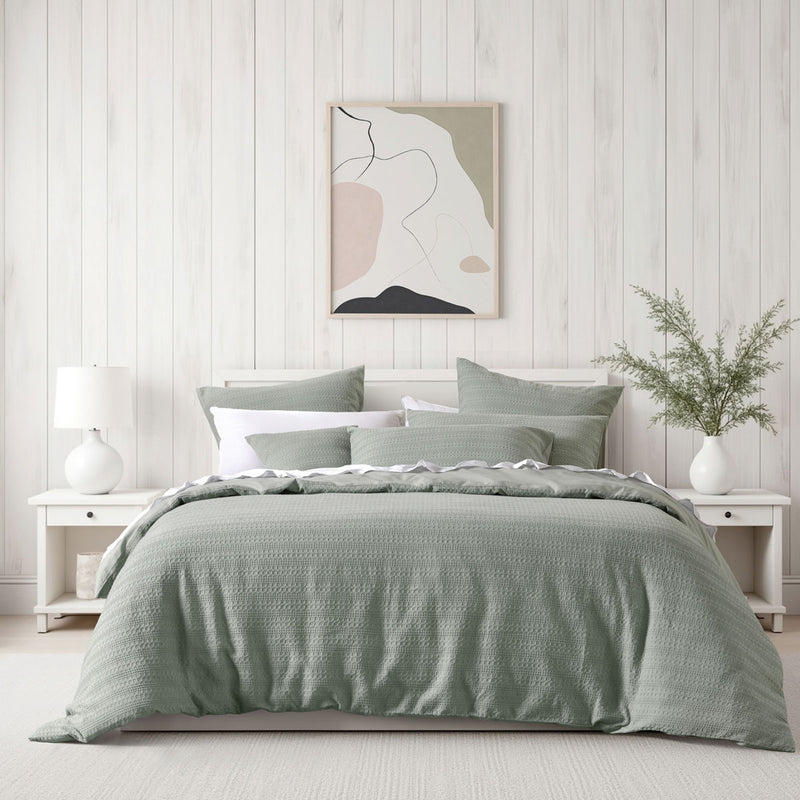 Bianca Kahlani Sage Waffle Quilt Cover Set Queen on bed with white bedside tables and abstract wall art in bedroom
