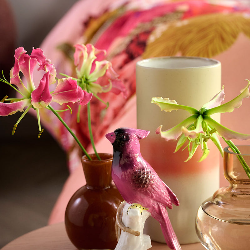 Decorative pink bird figurine with floral stems and candles against Oilily Livia Multi Cotton Floral Quilt Cover Set Queen background