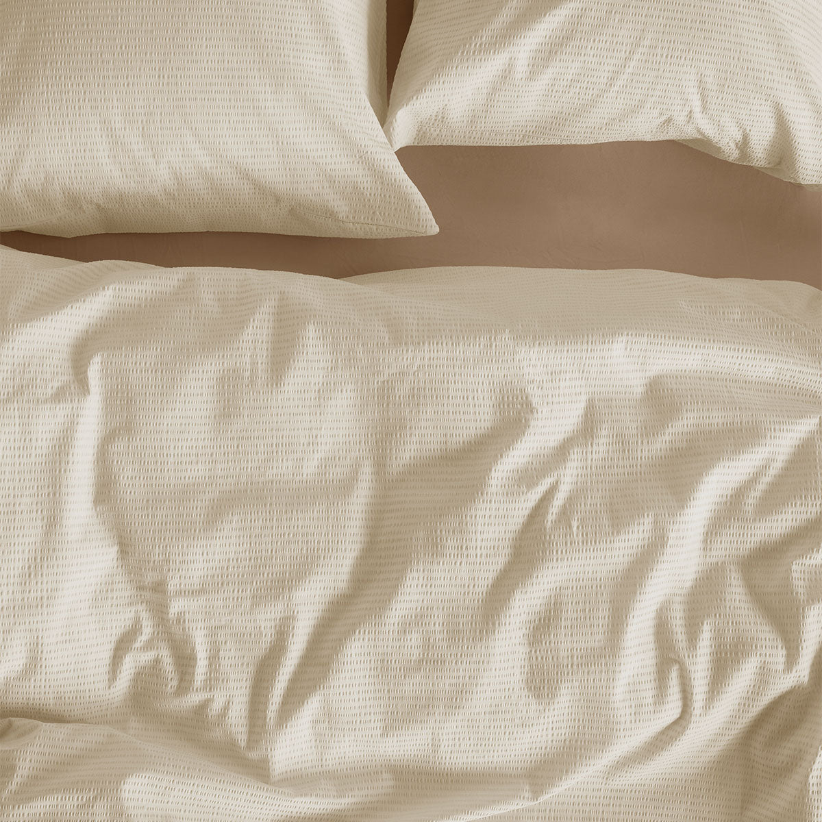 Bedding House Summer Sand Seersucker Cotton Quilt Cover Set King in sand color on a bed with matching pillowcases