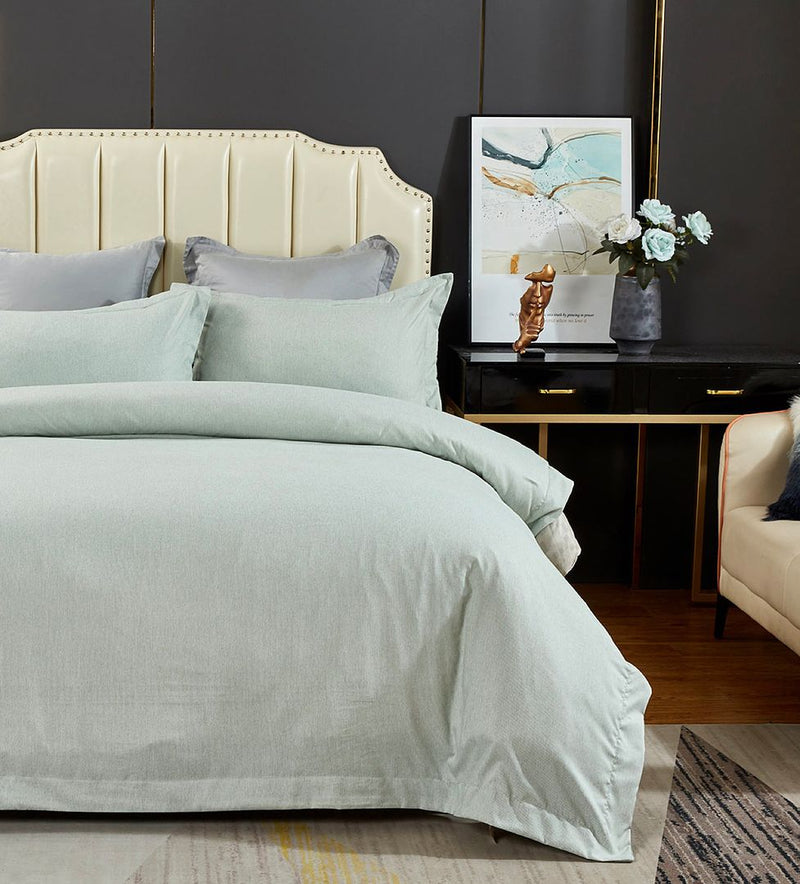 Tailored Super Soft Quilt Cover Set - Queen Size in light green on bed with cream headboard and black bedside table