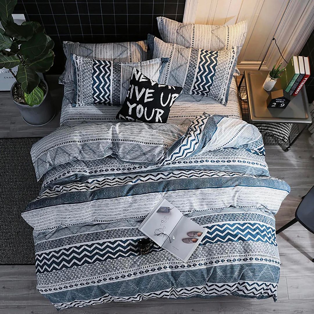 Dennings Super King Size Quilt/Doona/Duvet Cover Set with patterned blue and gray design on bed styled in bedroom furniture setting