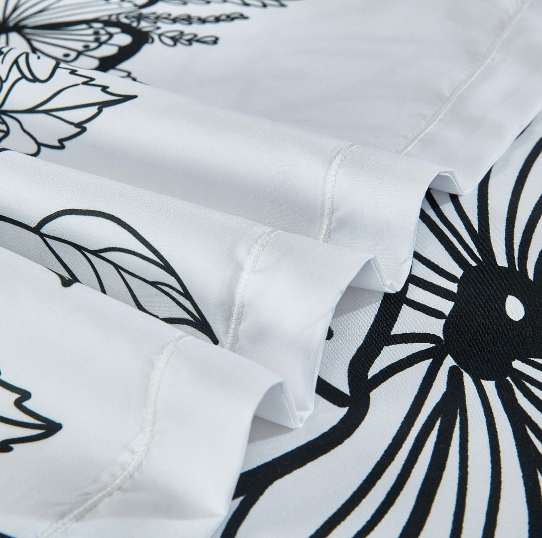Close-up of Viene Floral Quilt Cover Set - Queen Size showing black and white floral pattern and fine stitching detail