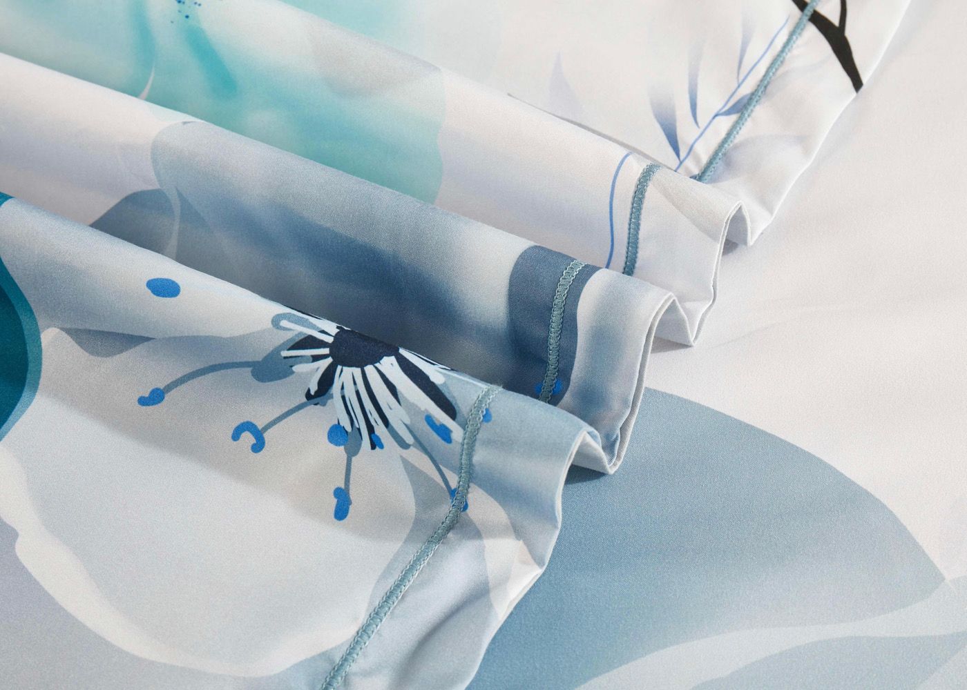 Close-up of Julieta Floral Quilt Cover Set - Super King Size fabric with blue and white floral design and neat stitching detail