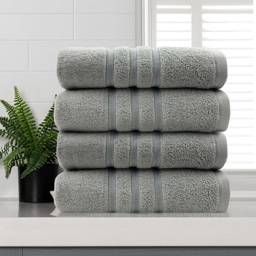 amor classic dobby stripe super soft premium cotton hand towel 4 pcs silver stacked on white surface near window and plant