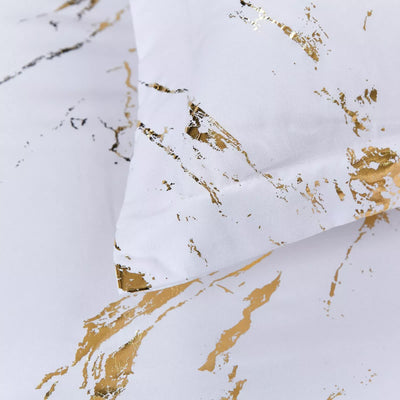 Cloud Rest Bedding Collection – Minimal 3‑Piece Comforter with white fabric and gold abstract print, close-up on bedding texture