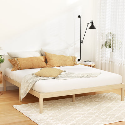 Bruno Minimalist King Solid Pinewood Bed Frame in natural wood finish with white bedding and rustic cushions in bright bedroom setting