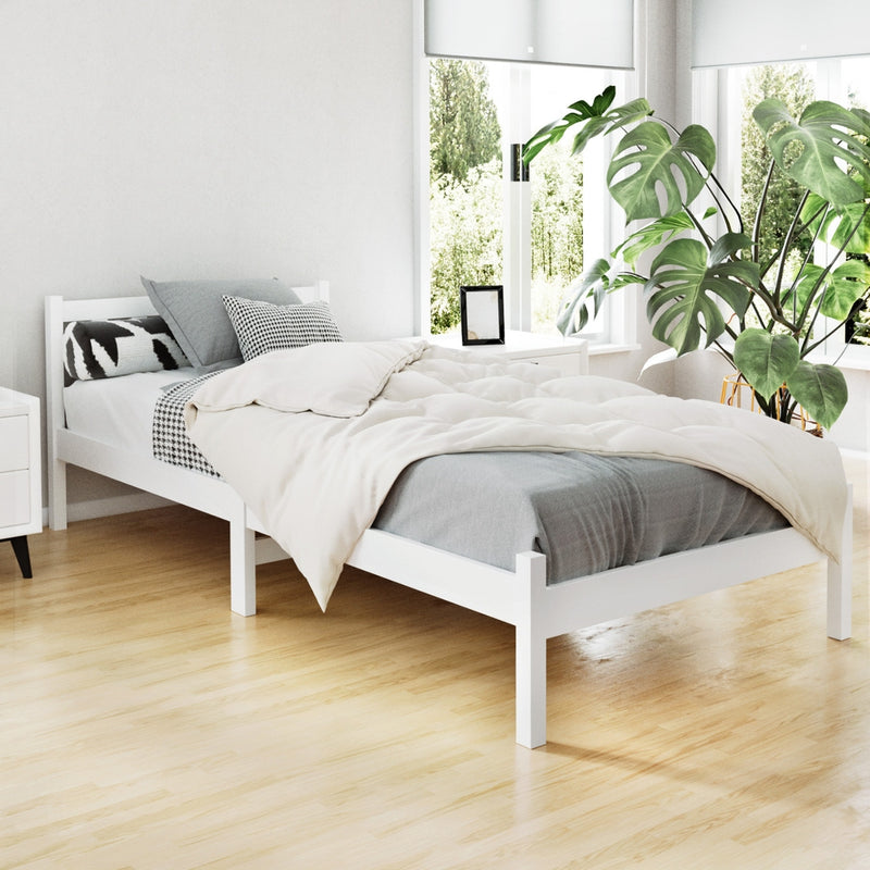 Whitehaven Wooden Single Bed Frame White in a bright bedroom with wooden floor and green plants by the window