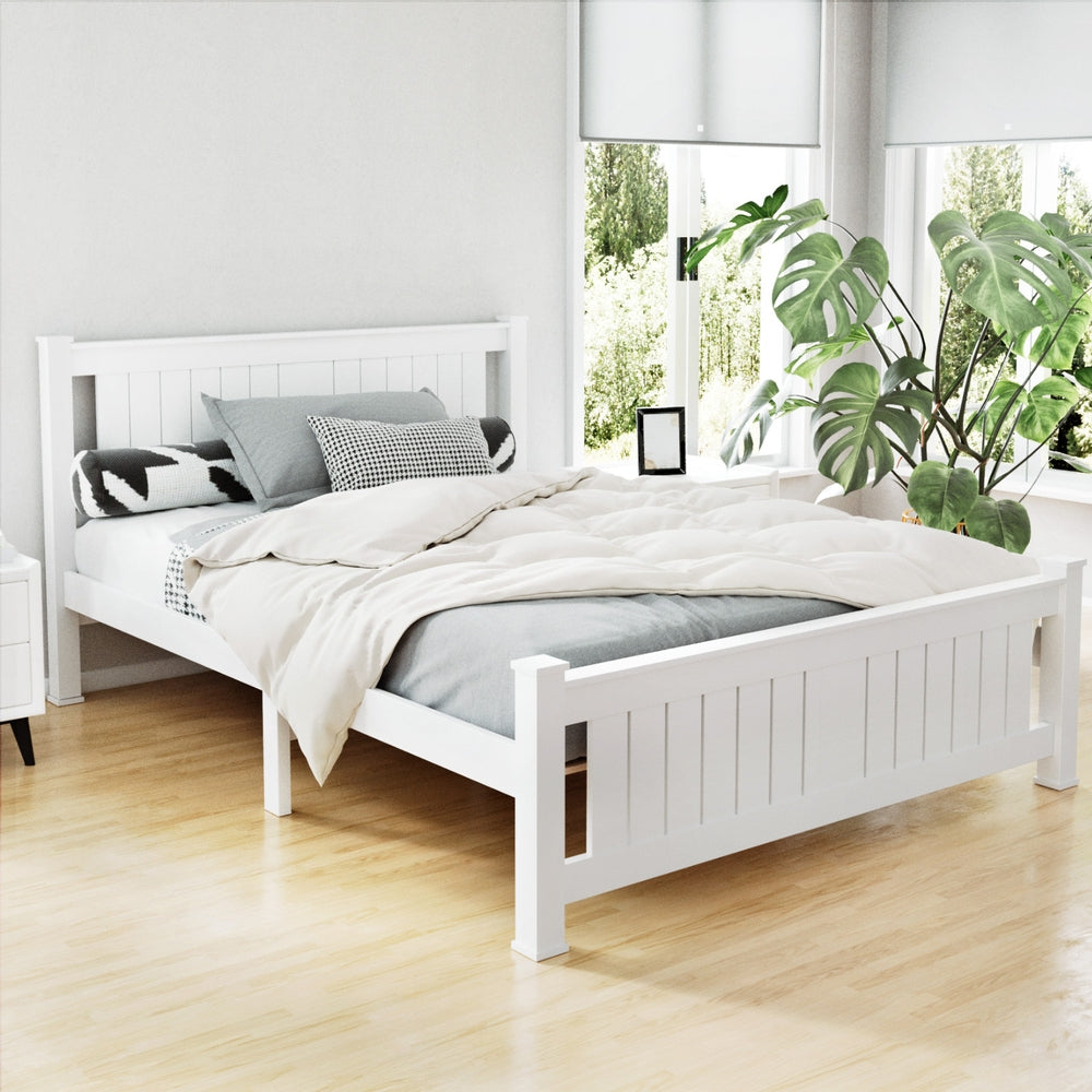 Airlie Wooden Double Bed Frame White with slatted headboard and footboard in bright bedroom setting with bedding and plants