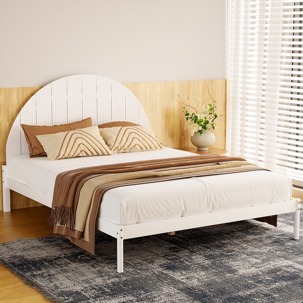Daly Queen Wooden Bed Frame White with semicircular headboard, white frame, brown pillows, and beige throw in bedroom setting