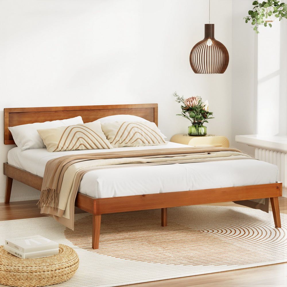Splay Queen Wooden Bed Frame Walnut in bedroom setting with beige bedding, decorative pillows, and modern wood pendant light