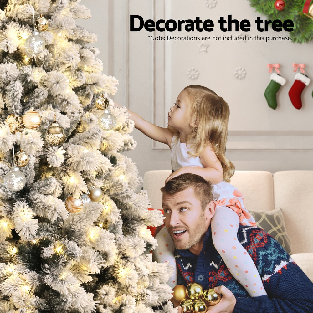 6FT / 1.8M Snow Flocked Christmas Tree – 828 Tips – Pre-lit 350 Warm White LED Lights (8 Modes) in festive living room setting