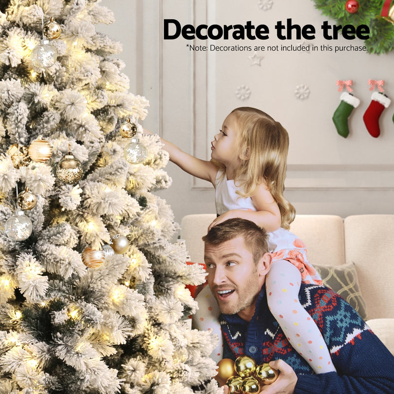 6FT / 1.8M Snow Flocked Christmas Tree – 828 Tips – Pre-lit 350 Warm White LED Lights (8 Modes) in festive living room setting