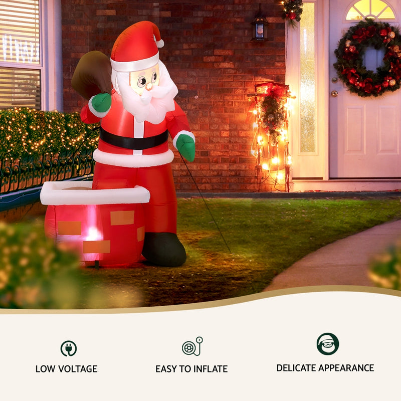 Christmas Inflatable Santa Illuminated Decorations with glowing lights, set outdoors by a decorated house entrance at night